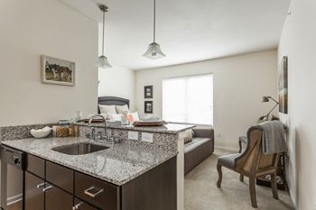 our apartments offer a kitchen and living room with a couch at 310 at Nulu Apartments-Student, Louisville, 40202